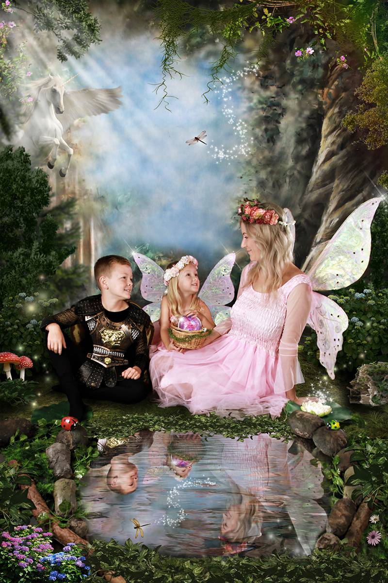 The mother, boy, and girl sit by a pond in a magical, enchanted forest